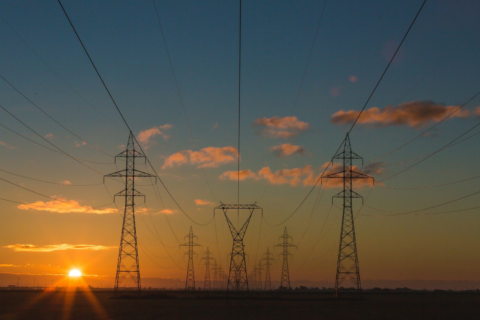 Pylônes électriques et lignes haute tension au coucher du soleil